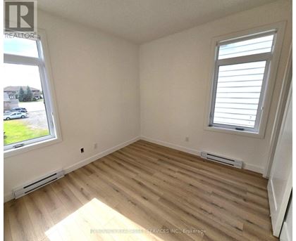 A room with wooden flooring and a window with blinds.