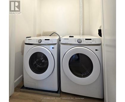 Two white front load washing machines in a laundry room.