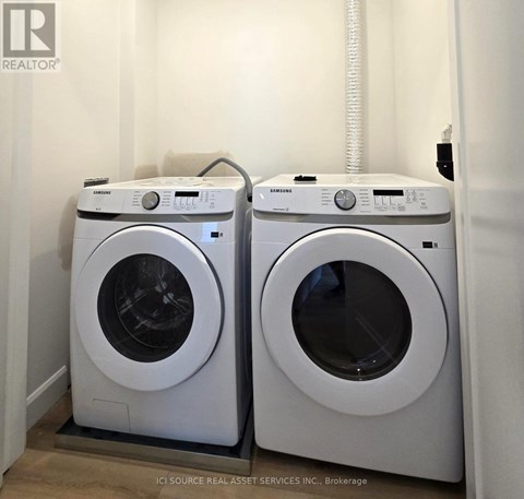 Two white front load washing machines in a laundry room.