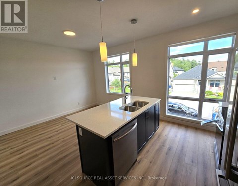 A kitchen with a sink and a window overlooking a parking lot.