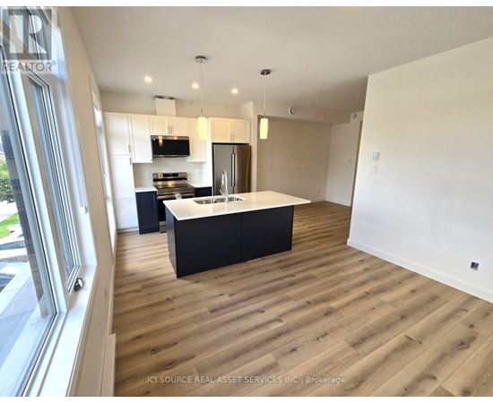 A modern kitchen with wooden floors and a large island.