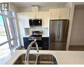 A kitchen with a sink, stove, and refrigerator.