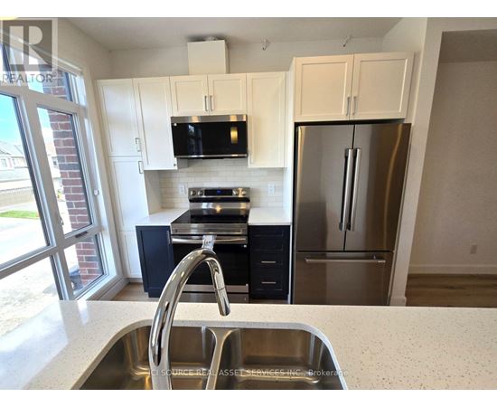 A kitchen with a sink, stove, and refrigerator.