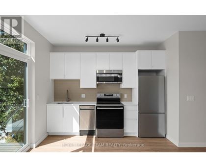 A modern kitchen with white cabinets and stainless steel appliances.
