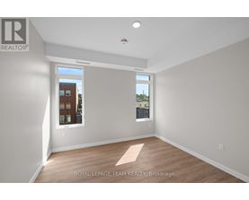 A room with a window showing a view of a building with the text "ROYAL LEPAGE TEAM REALTY, Brokerage" on the wall.