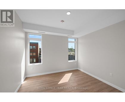 A room with a window showing a view of a building with the text "ROYAL LEPAGE TEAM REALTY, Brokerage" on the wall.