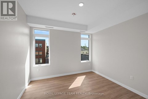 A room with a window showing a view of a building with the text "ROYAL LEPAGE TEAM REALTY, Brokerage" on the wall.