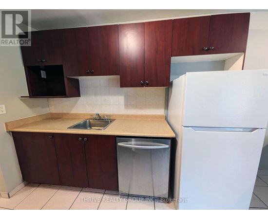 A kitchen with brown cabinets and a white refrigerator.