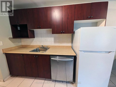 A kitchen with brown cabinets and a white refrigerator.