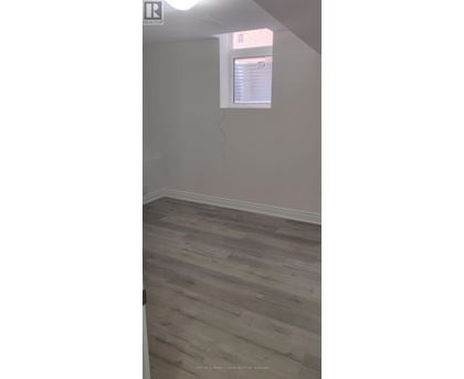 A room with a window and wooden flooring.