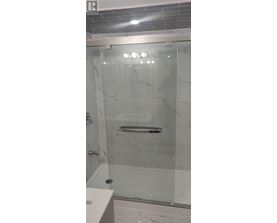 A white bathroom with a glass shower door.