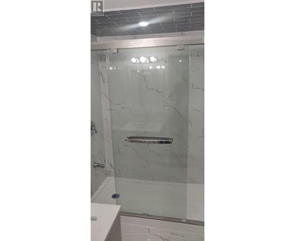 A white bathroom with a glass shower door.