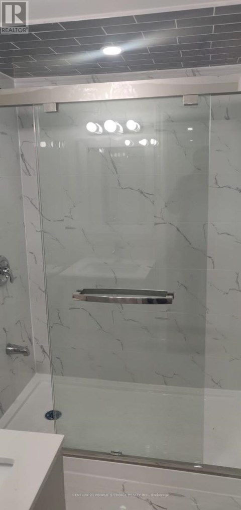 A white bathroom with a glass shower door.
