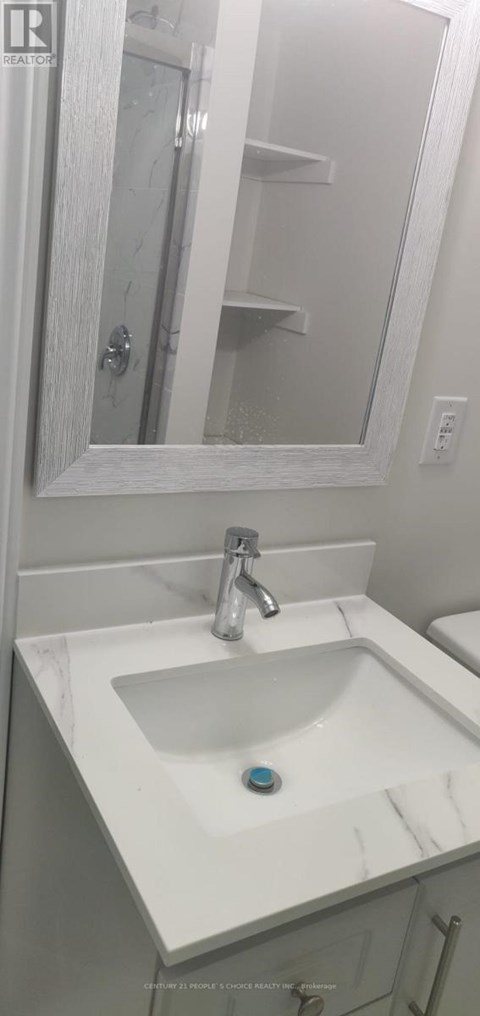 A white bathroom sink with a blue soap.