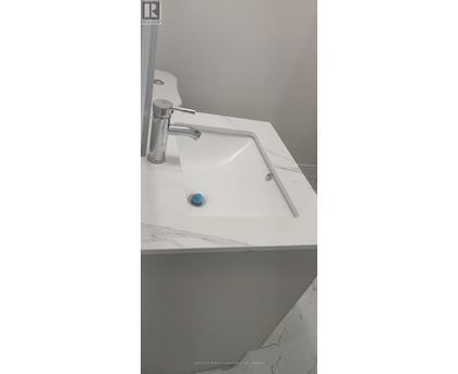 A white sink with a silver faucet and a blue knob.