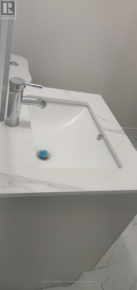 A white sink with a silver faucet and a blue knob.