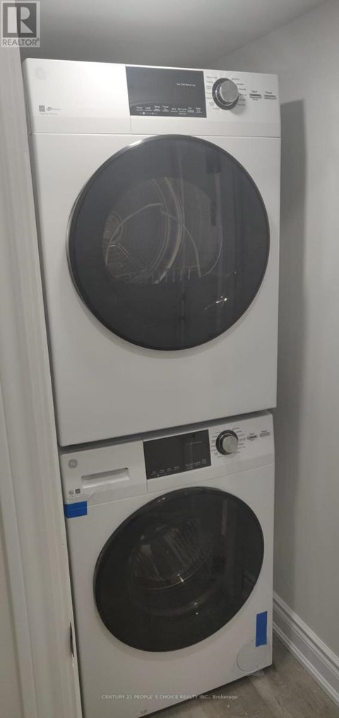 A white washing machine with a black door is stacked on top of another white washing machine with a black door.