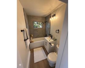 A bathroom with a white toilet, a white sink, and a white bathtub.