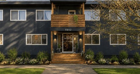 A modern house with a dark facade and a wooden front door.