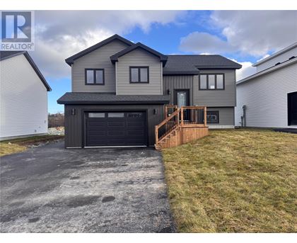 A modern house with a grey exterior and a black garage door.