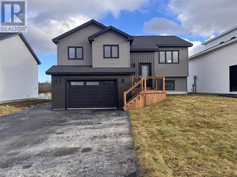 A modern house with a grey exterior and a black garage door.