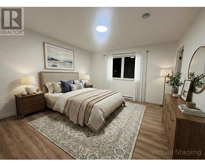 A bedroom with a large bed, a nightstand, and a dresser.