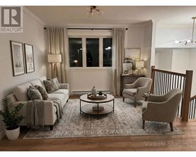 A living room with a grey couch, a coffee table, and a lamp.