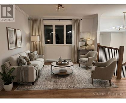 A living room with a grey couch, a coffee table, and a lamp.