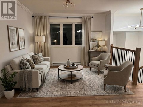 A living room with a grey couch, a coffee table, and a lamp.