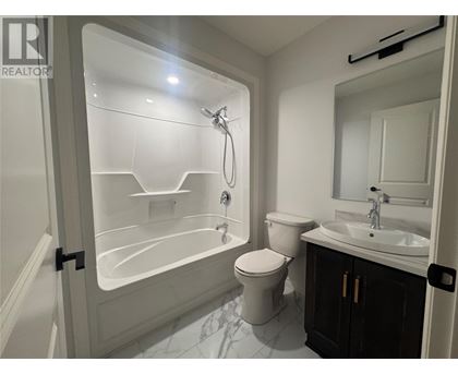A white bathroom with a toilet, sink, and shower.