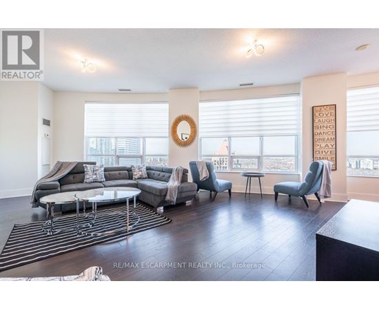 A living room with a grey sofa set and a wreath on the wall.