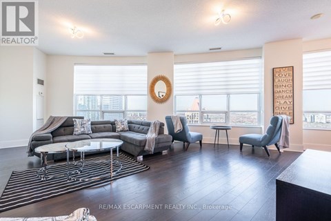 A living room with a grey sofa set and a wreath on the wall.