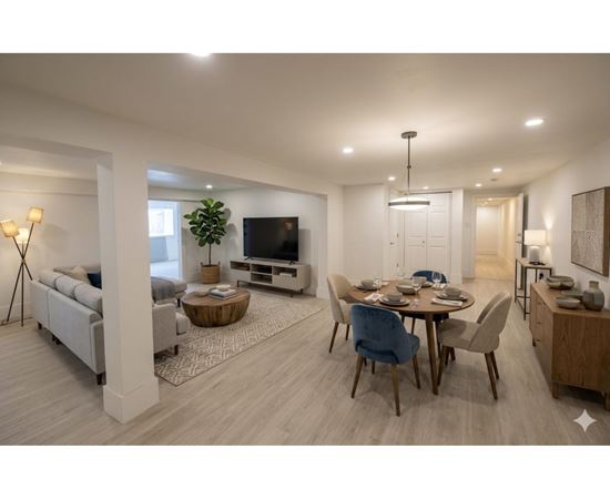 A modern living room with a dining area and a television.