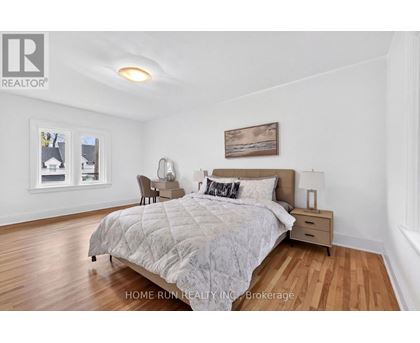 A bedroom with a large bed and a painting on the wall.