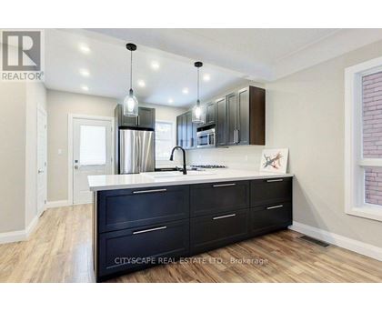 A kitchen with black cabinets and a white countertop.