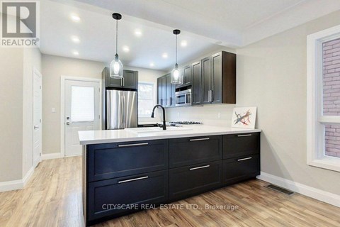 A kitchen with black cabinets and a white countertop.