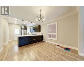 A well-lit kitchen with dark wood floors and a large island.
