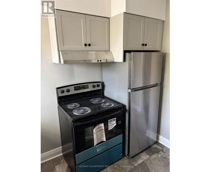A stainless steel refrigerator and stove in a kitchen.