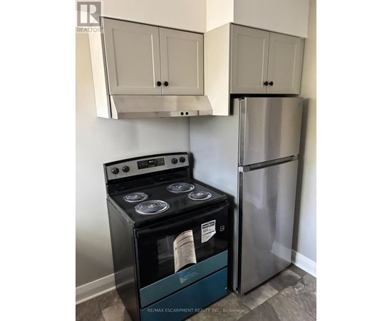 A stainless steel refrigerator and stove in a kitchen.