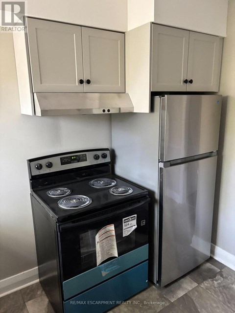 A stainless steel refrigerator and stove in a kitchen.