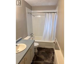 A bathroom with a toilet, sink, and bathtub.