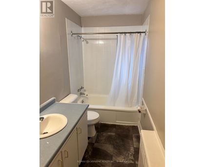 A bathroom with a toilet, sink, and bathtub.
