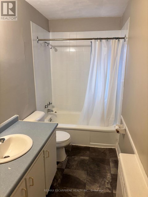 A bathroom with a toilet, sink, and bathtub.