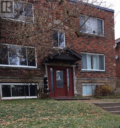 A red door is on the front of a brick building.