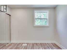 A room with a window and a wooden floor.