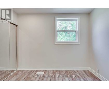 A room with a window and a wooden floor.