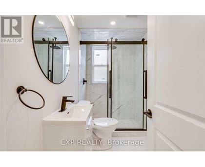 A bathroom with a toilet, sink, and mirror.
