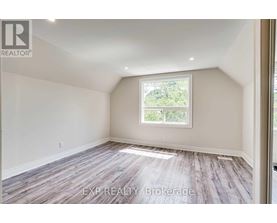 A room with a window and wooden flooring.