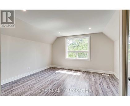 A room with a window and wooden flooring.