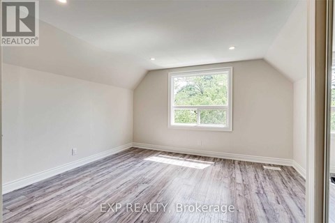 A room with a window and wooden flooring.